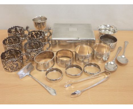 Five silver cup holders, 1919, six napkin rings, two salts en egg cup and four items of flatware and a cigarette box. 13oz we