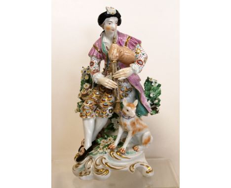 Derby porcelain "Pipe" Shepherd figure, seated with dog at foot and surrounded by flowering bocage on rococo scroll base. 18.