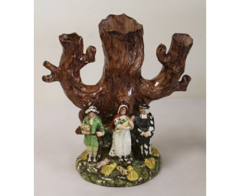 Early 19th century Staffordshire 'Tithe Pig' spill vase of tree trunk form surmounted by figures of a parson, shepherd with p