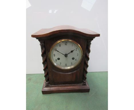 An oak mantel clock with barley twist supports, Arabic silvered dial, 8 day movement, 28cm high