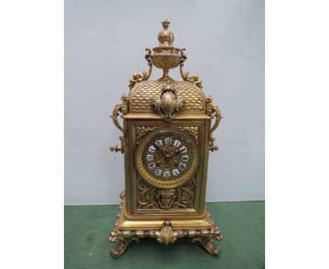 A French brass mantel clock surmounted by a urn decorated with classical form swags of fruit and vines with pendulum, 47cm hi