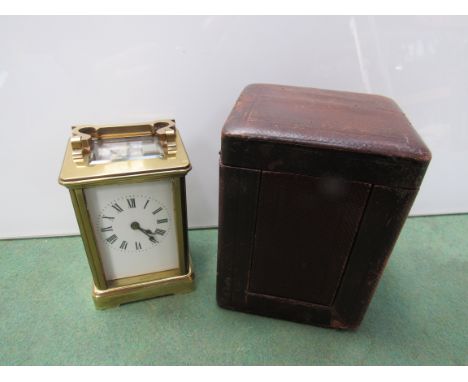 An early 20th Century brass carriage clock, Roman enamel dial, with leather carry case and key, 11cm high