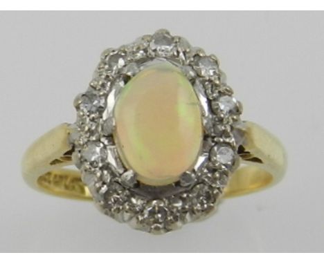 An 18 carat yellow gold, diamond, and opal cluster ring, the shank stamped 18ct PLAT. 