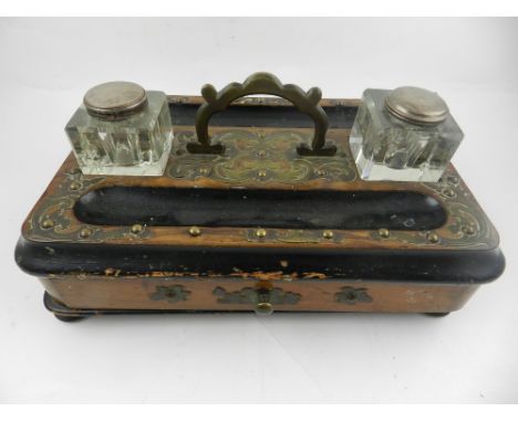 A mid 19th century walnut and partially ebonised ink stand, decorated with scrolling metalwork to top, having glass inkwell. 