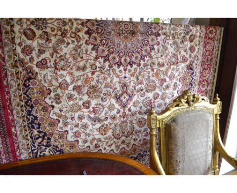 A Keshan style carpet, having a central medallion on a cream and red ground, contained by many borders. L.230cm W.160cm