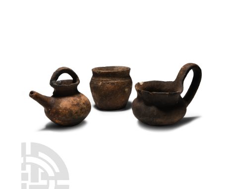Early-Late Bronze Age, 2700-1200 B.C.. Comprising: a barrel-shaped jar with flared rim; a spouted vessel with strap handle; a