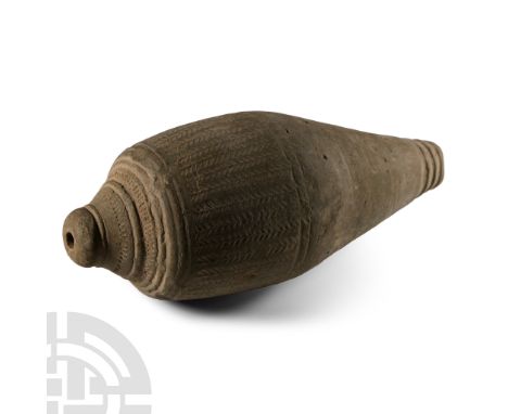 13th-15th century A.D.. A hollow vessel with cylindrical body, carinated shoulder, short neck and domed mouth, bands of impre
