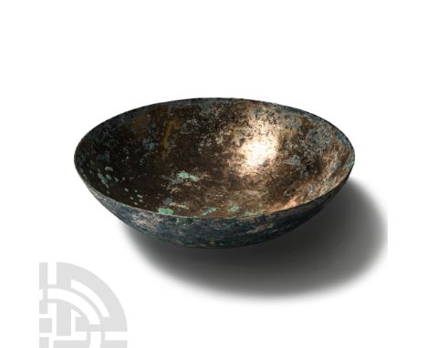 Late 2nd-early 1st century B.C.. With high tin content, the body formed with a D-section wall and rounded base, damaged. Cf. 