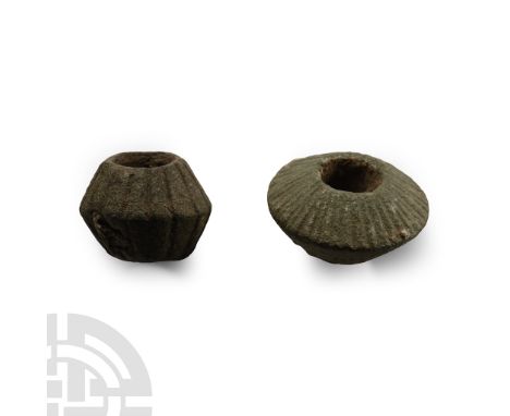 1st-4th century A.D.. Comprising a squat biconvex whorl with radiating lines to one face, and a taller version with lines to 