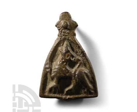 11th century A.D.. Heater-shaped in profile with trefoil knop above and fixing pin; high-relief profile wolf with head thrown