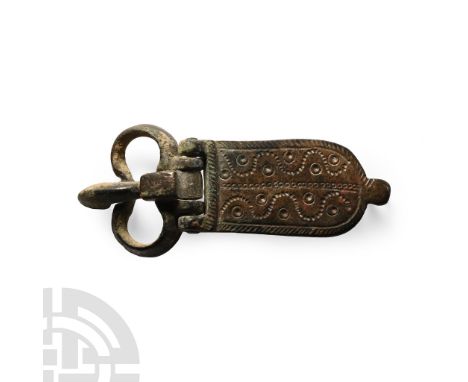 Circa 12th-13th century A.D.. With a kidney-shaped loop and tongue-shaped plate with hatched border, wavy lines of punched pe