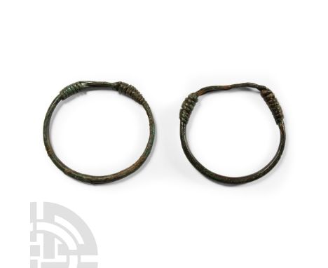 2nd-3rd century A.D.. Each a D-section hoop with the tapering ends coiled about the shank.  62.6 grams total, 66-71 mm (2 5/8