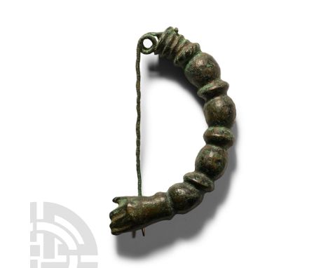 8th-6th century B.C.. Substantial arched bow formed with bulbs and collar, stepped finial with coil and spring; the catch for
