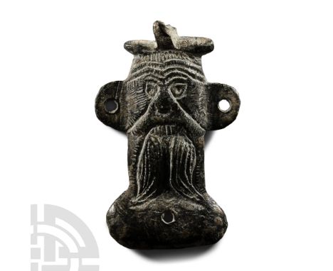 12th-14th century A.D.. Mount fragment formed as a facing mask with lateral flanges; the face formed with undulating lines to