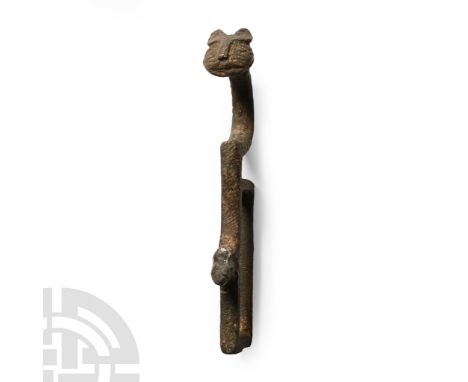 12th-15th century A.D.. Comprising a rectangular loop with remains of a stud, stylised lion's head finial with a long curved 