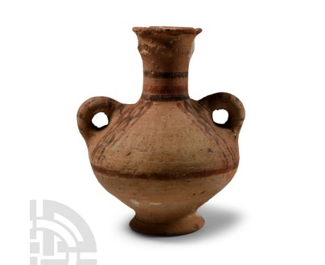 Middle Bronze Age, 2000-1650 B.C.. Biconvex in profile with small flared foot, trumpet-shaped mouth and two lateral loop hand