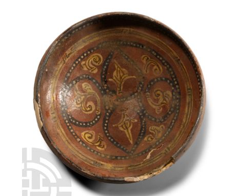13th-14th century A.D.. With carinated profile, band of pointillé and other ornament surrounding scrolled tendrils.  555 gram