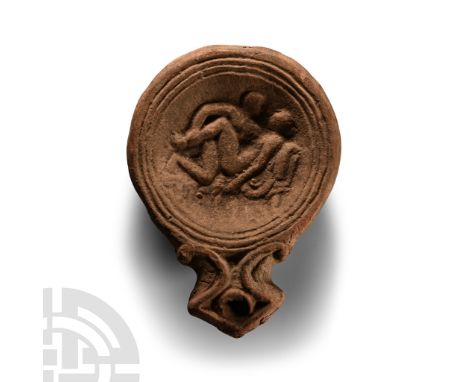 1st century A.D.. With ribbed shoulder and recessed discus, short nozzle with raised volute scrolls, low-relief scene with tw