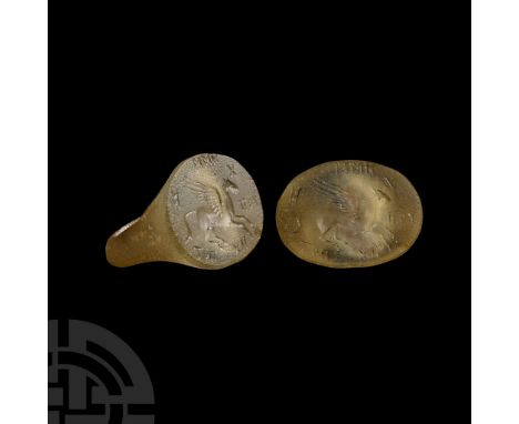 3rd-2nd century B.C.. Aqua-coloured glass, flared shoulders and ellipsoid bezel with intaglio winged horse motif, surrounding