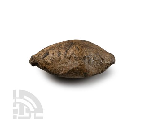 1st century B.C.. Biconical lead slingshot (glans) with inscription in Latin letters 'CN' (Cneius) 'MAG' (Magnus) on one side