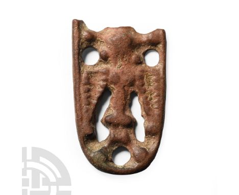 10th-11th century A.D.. Tongue-shaped with openwork design, median figure of a bird with wings spread, domed bosses to the fr