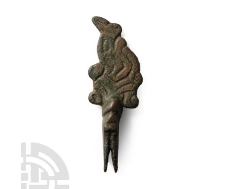10th-11th century A.D.. Elongated plate with longitudinal split and rivet; openwork scrolled tendril motif developing to a wo