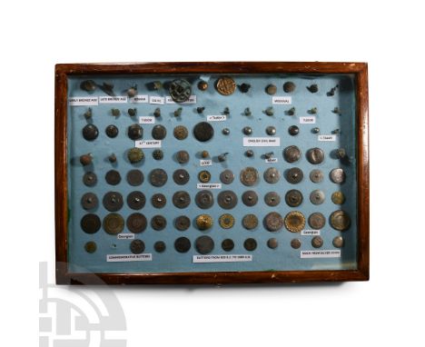 850 B.C.-1800 A.D.. Collection of mainly bronze and silver buttons and fasteners, labelled and mounted in a glazed wooden dis