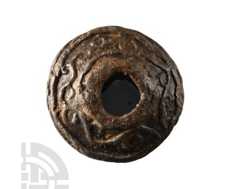 2nd century B.C.-1st century A.D.. Biconvex in profile with raised rims to the socket, band of La Tène style scrolled tendril