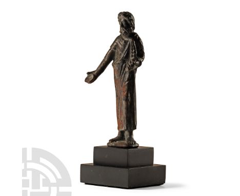 4th-2nd century B.C.. Modelled standing barefoot on an irregular base, wearing an ankle-length chlamys over a short-sleeved t