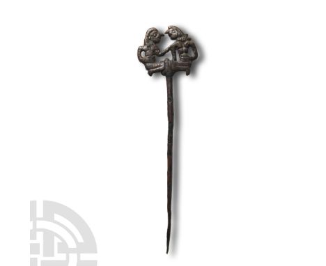 1180-700 B.C.. With tapering shaft and openwork bifacial finial depicting two kneeling warriors facing each other, one holdin