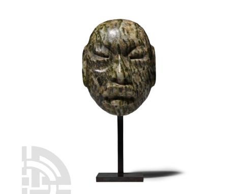 900-400 B.C. or later. A striated green stone head or mask carved in the half-round with semi-naturalistic facial features, i