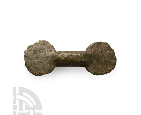 Circa 6th-8th century A.D.. Of ansate type with lobe finials; surface covered with ring-and-dot motifs.  11.3 grams, 57 mm (2