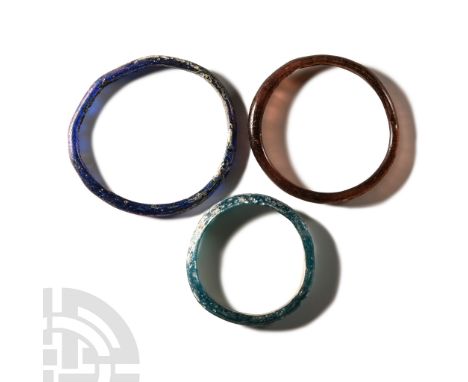 Circa 2nd-4th century A.D.. Comprising one round-section in deep blue, one similar in deep red, and a D-section in pale blue/
