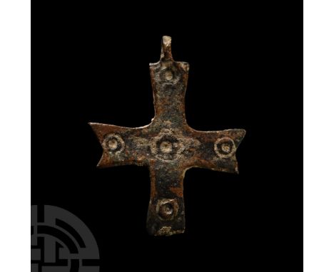 6th-8th century A.D.. Cruciform pendant with impressed ring-and-dot motifs to the obverse, each arm with notched end. Bailey,