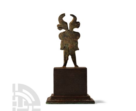 1st millennium B.C.. Flat in section standing figure with legs spread and arms held at the sides, two addorsed bull-heads abo