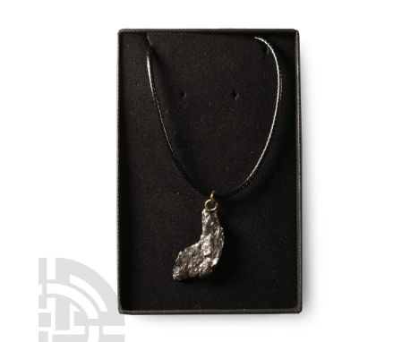 Fell 6000-5000 years B.P.. A nickel-iron meteorite (IAB) set with a suspension loop and hung from a cord.  8 grams, 34 mm (1 