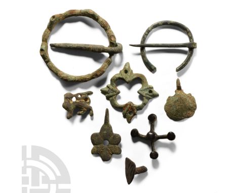 Circa 14th-15th century A.D.. Including a ring brooch with conical sockets, a scallop mount, a heater-shaped heraldic stud an