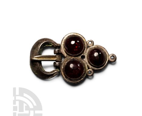 Circa 6th-7th century A.D.. Comprising: plate formed as three discs each set with a garnet cabochon, three rings to the edges