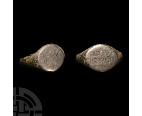 13th-14th century A.D.. Comprising a slender bronze hoop expanding at the shoulders, silver intaglio with an inscription in t