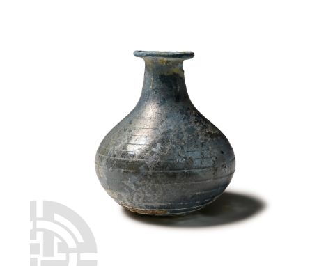 3rd-4th century A.D.. Piriform in profile with slight dimple to base, squat body, tubular neck with flared and rolled mouth; 