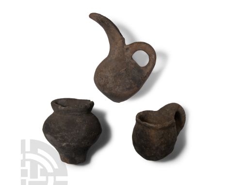 Middle Bronze Age, circa 2000-1650 B.C.. Comprising: dipper cup with loop handle; juglet with scooped spout; biconvex jar wit
