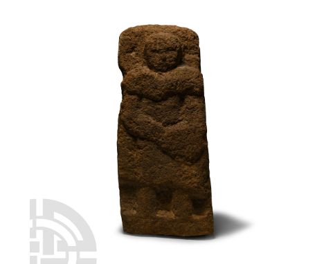 Circa 5th-3rd century B.C.. Wedge-shaped in section with figure carved in the half-round to one face, warrior with armoured c