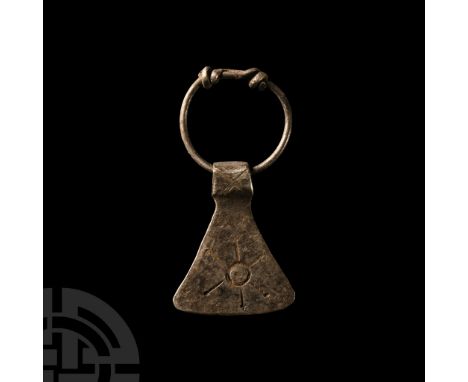 Circa 9th-11th century A.D. or earlier. Axehead with sunburst motif to one face; suspension loop with coiled ends.  1.92 gram