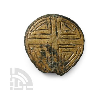 8th-9th century A.D.. Discoid panel with one gilt face, incised concentric quadrants forming a voided cross; attachment point