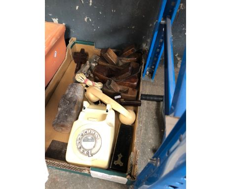 A box containing old woodworking tools, planes and an old telephone 