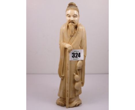 ANTIQUE ORIENTAL IVORY, a carved figure of elderly man with walking stick and gourd water flask, signed to base, 8.25" height