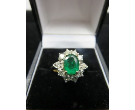 EMERALD & DIAMOND CLUSTER RING, oval cushion cut emerald surrounded by 10 diamonds on a yellow gold mount, ring size K 