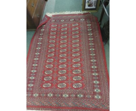 MIDDLE EASTERN CARPET, with multiple medallions on a red ground within multiple borders, 120cm x 180cm