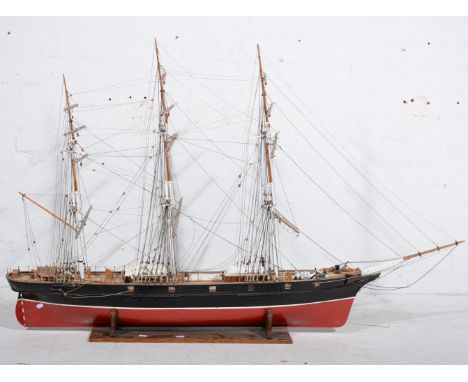 A large wooden model of the record breaking Tea Clipper "Fiery Cross", fully rigged, with black and red hull, mounted on a cu