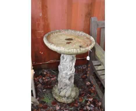 A MODERN COMPOSITE BIRD BATH with a tree trunk effect base and circular top, height 75cm  Condition Report: weathered chip to